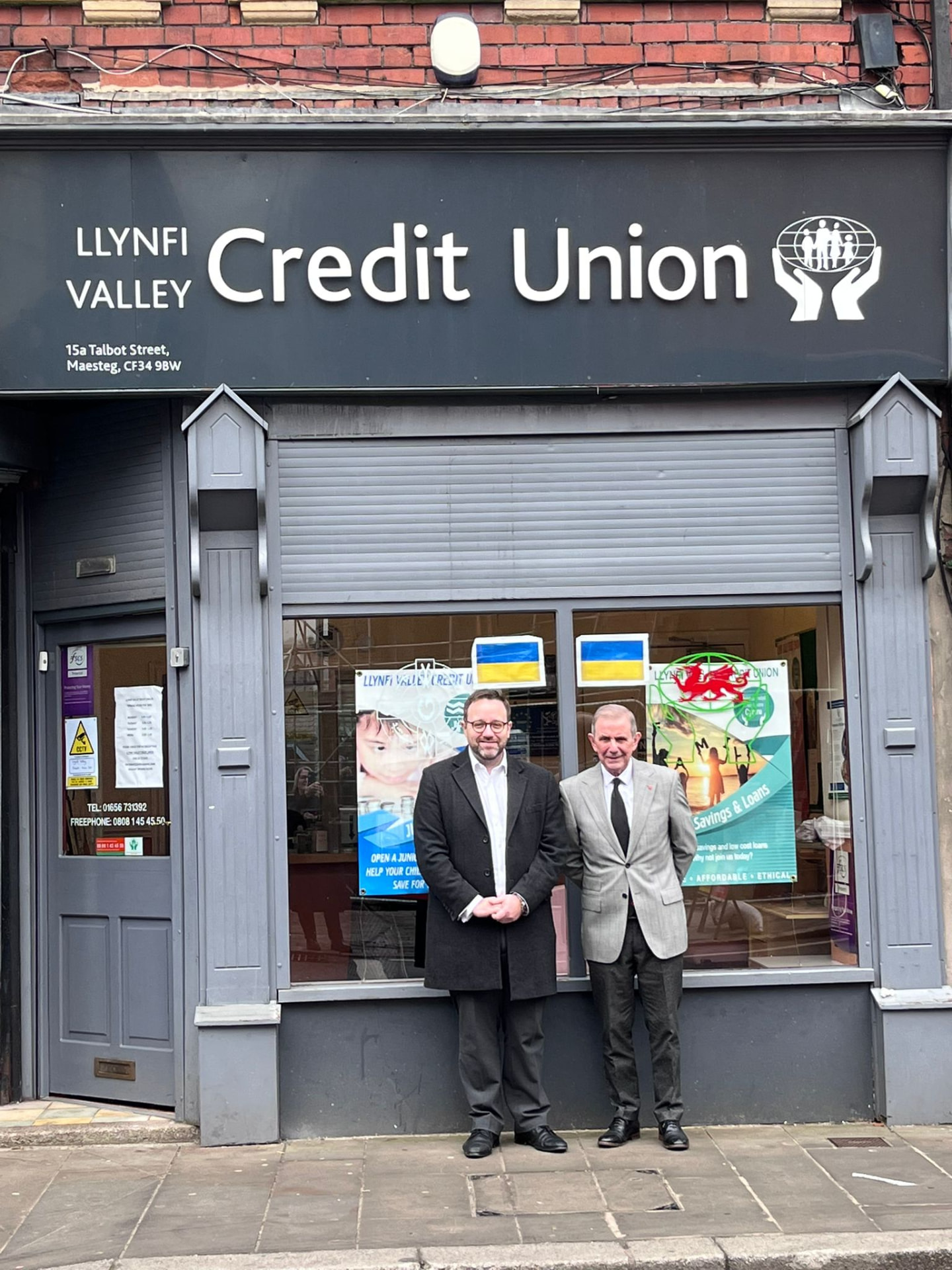 The Llynfi Valley Credit Union branch on Talbot Street, Maesteg, with two members standing on the pavement outside